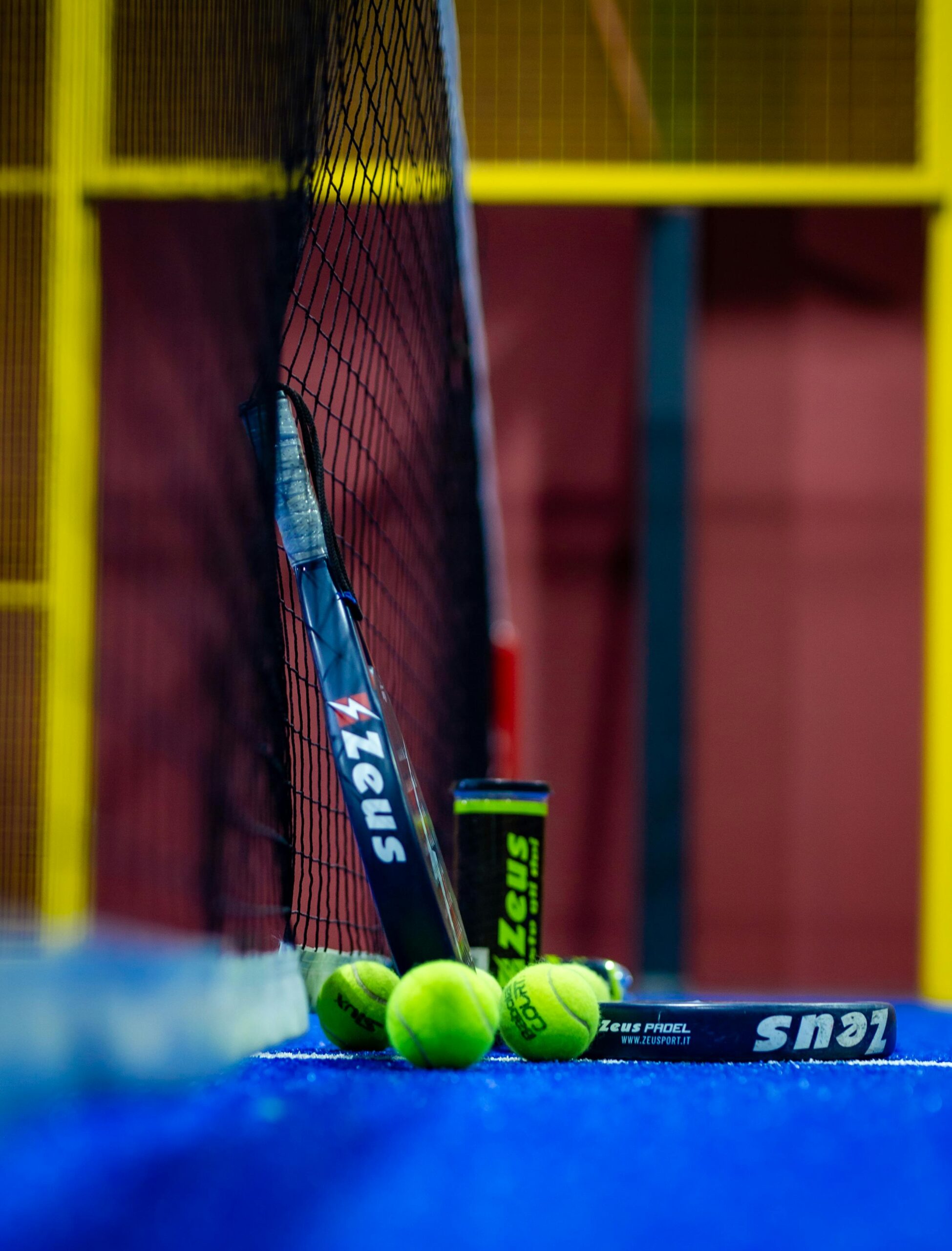 A player hitting a padel groundstroke from the baseline