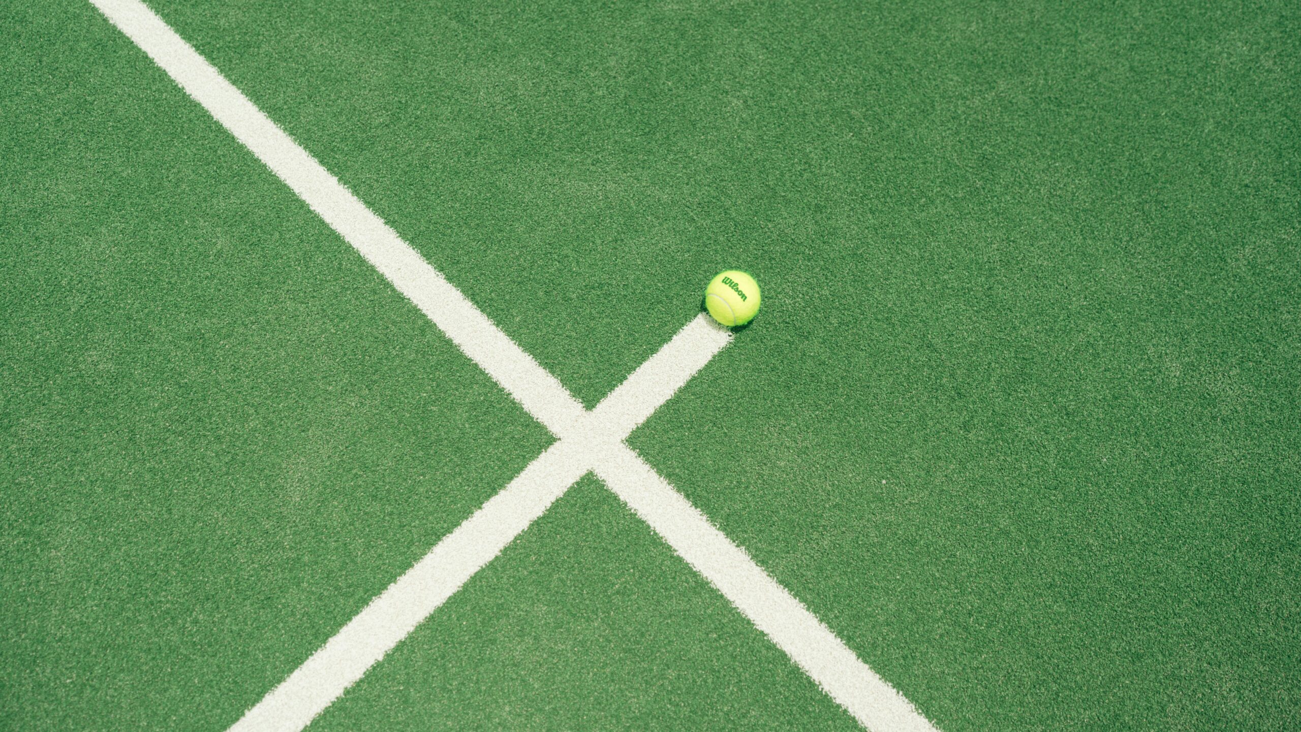 A padel ball on the court line